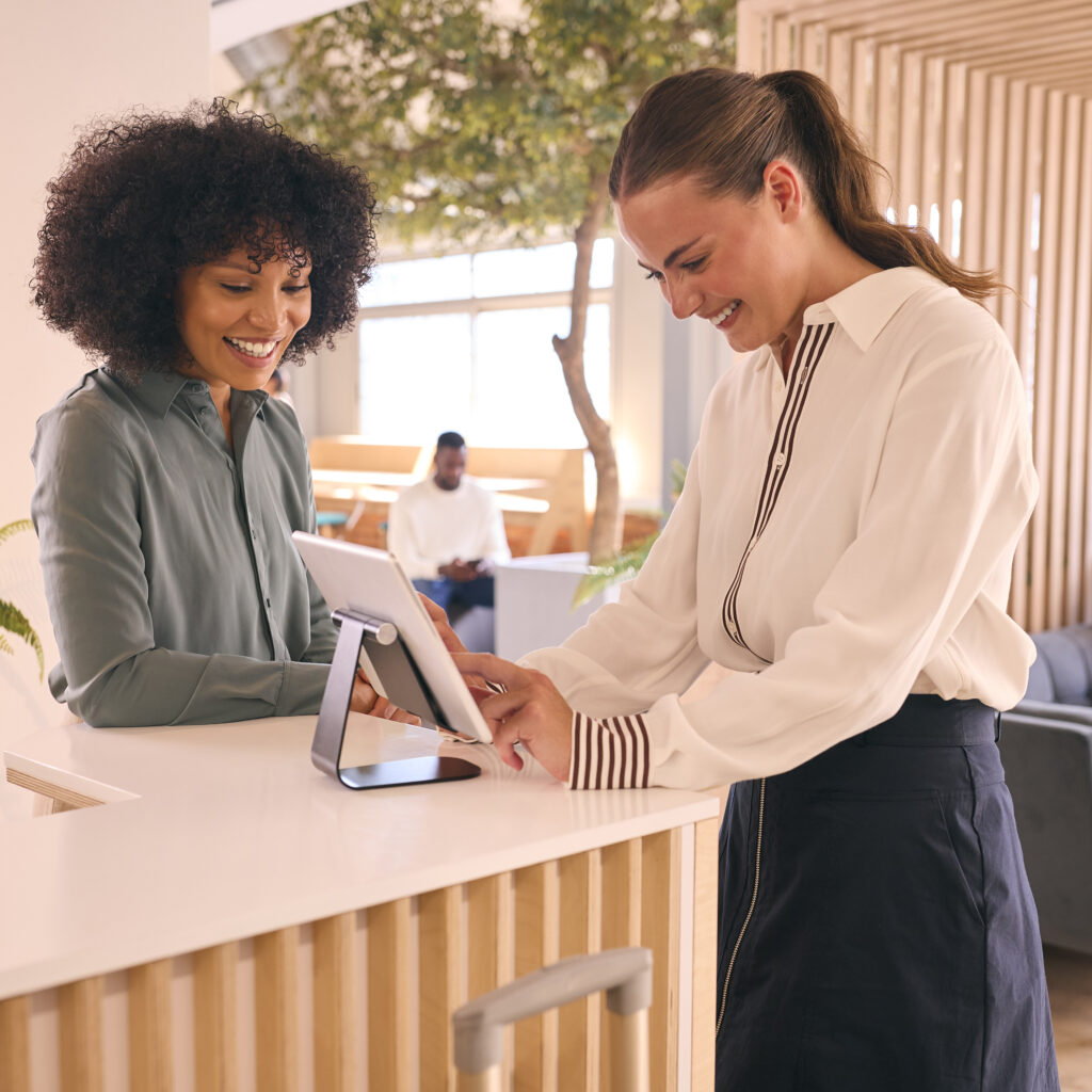 businesswoman-with-suitcase-checking-hotel-reception-conference